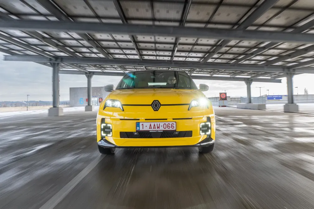 {"fr":"Renault Mégane jaune sous abri solaire, avant dynamique sur route humide.","nl":"Gele Renault Mégane onder zonnepanelen, vooraanzicht op natte weg."}